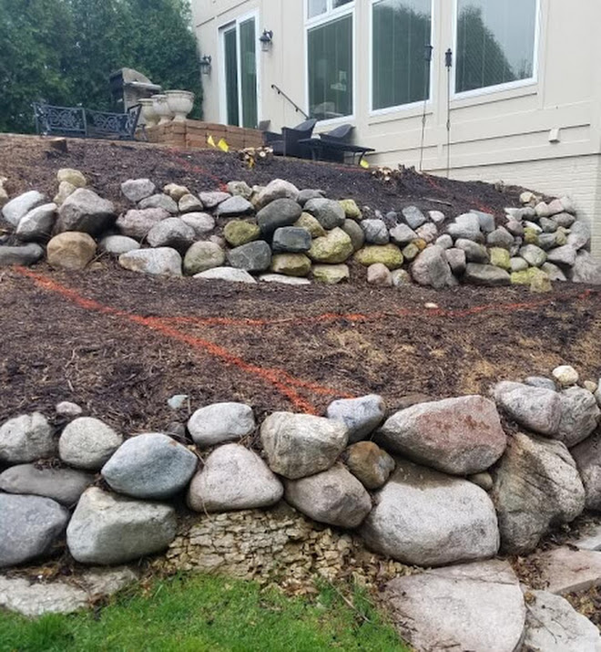 Structural retaining wall and site grading in progress by Arbor Rock & Wall Landscaping in Central Iowa.